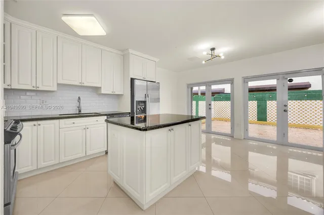 a kitchen with a sink a counter top space and windows