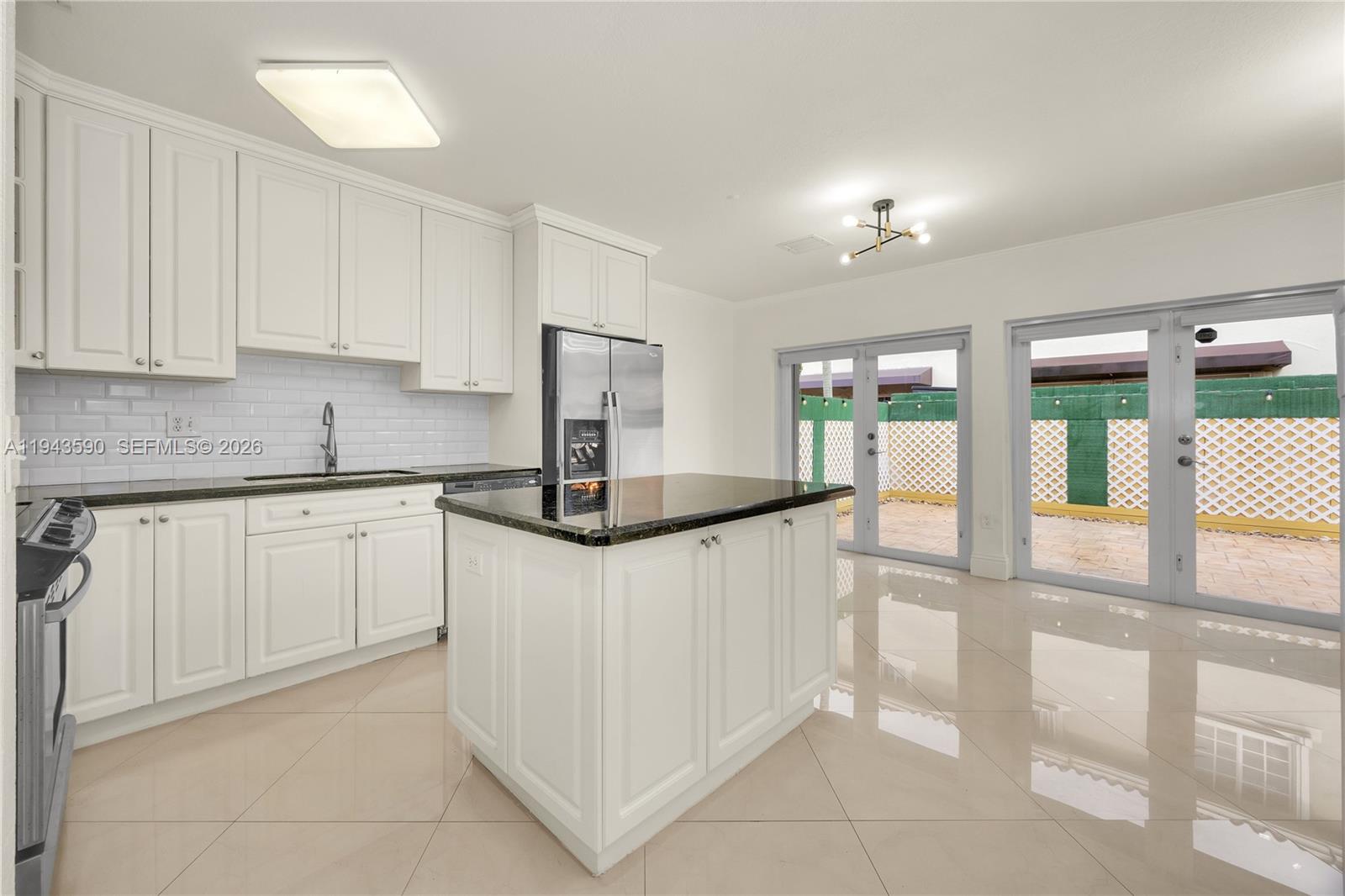 7773 Southwest 94th Lane Miami, FL 33156 - Photo 7 of 50 a kitchen with stainless steel appliances granite countertop a refrigerator sink and white cabinets