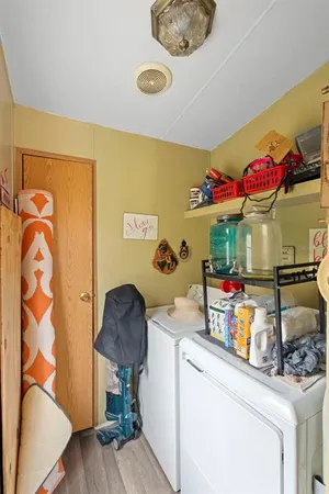 a kitchen with a refrigerator and a wooden floor