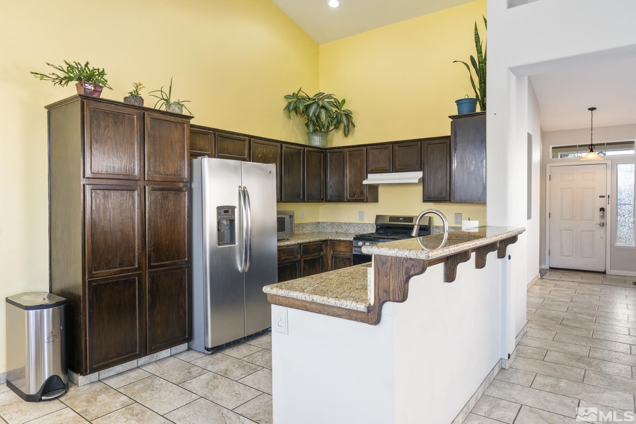 11760 Claim Stake Drive Reno, NV 89506 - Photo 9 of 22 a kitchen with stainless steel appliances granite countertop a refrigerator a stove and a sink