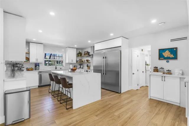 a kitchen with stainless steel appliances a stove top oven a sink dishwasher and a refrigerator