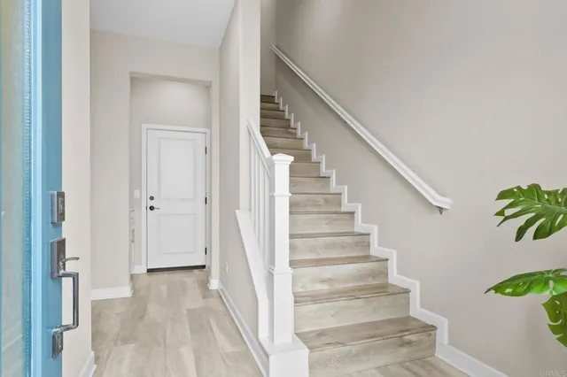 a view of staircase with lots of frames on wall and a potted plant