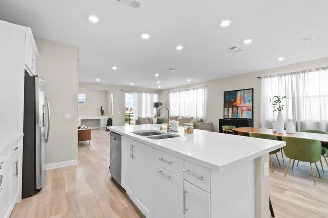 a kitchen with a sink a stove a refrigerator and chairs