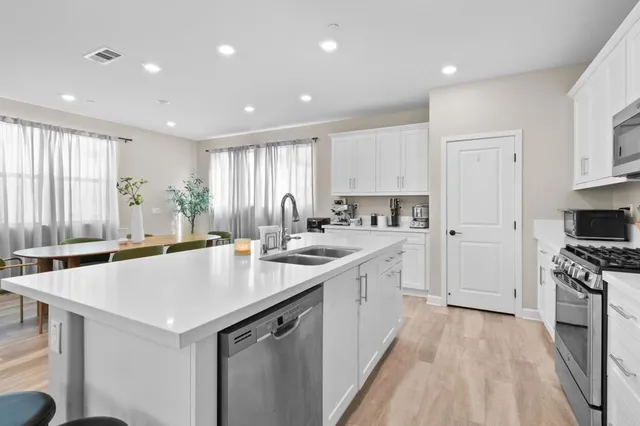 a kitchen with a sink a stove a refrigerator and a oven