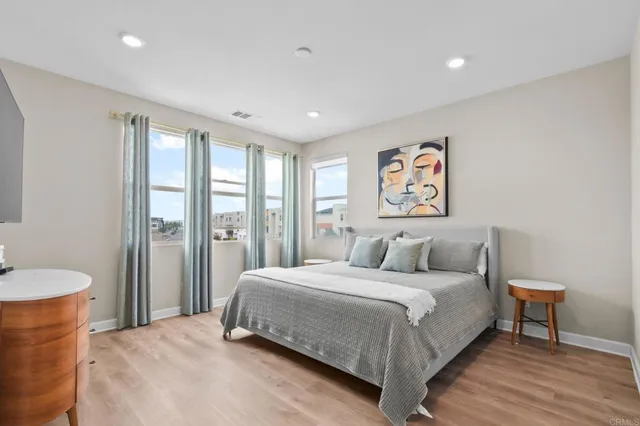 a bedroom with a large bed and a wooden floor