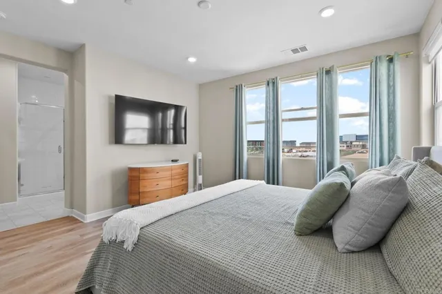 a bedroom with a large bed and a flat tv screen