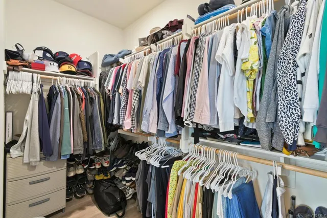 a view of walk in closet with clothes and shoes