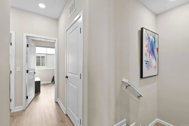 a view of a hallway with wooden floor and closet area