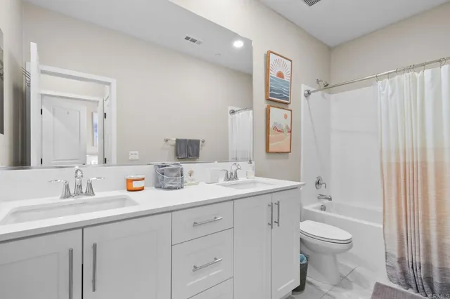 a bathroom with a toilet a sink a mirror a shower and vanity