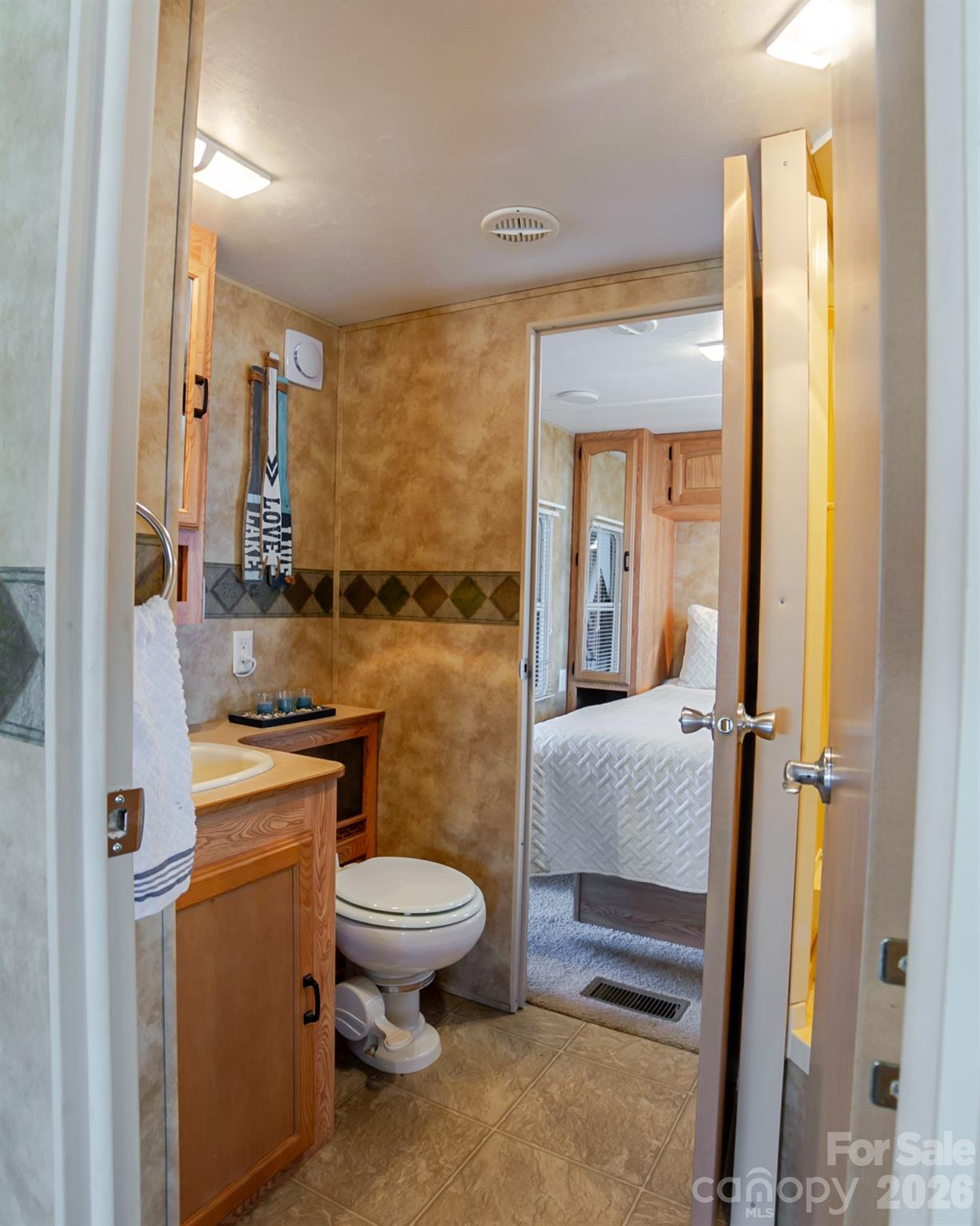 166 Badin Lake Road, Unit 757 New London, NC 28127 - Photo 20 of 45 a bathroom with a granite countertop sink a toilet and a shower