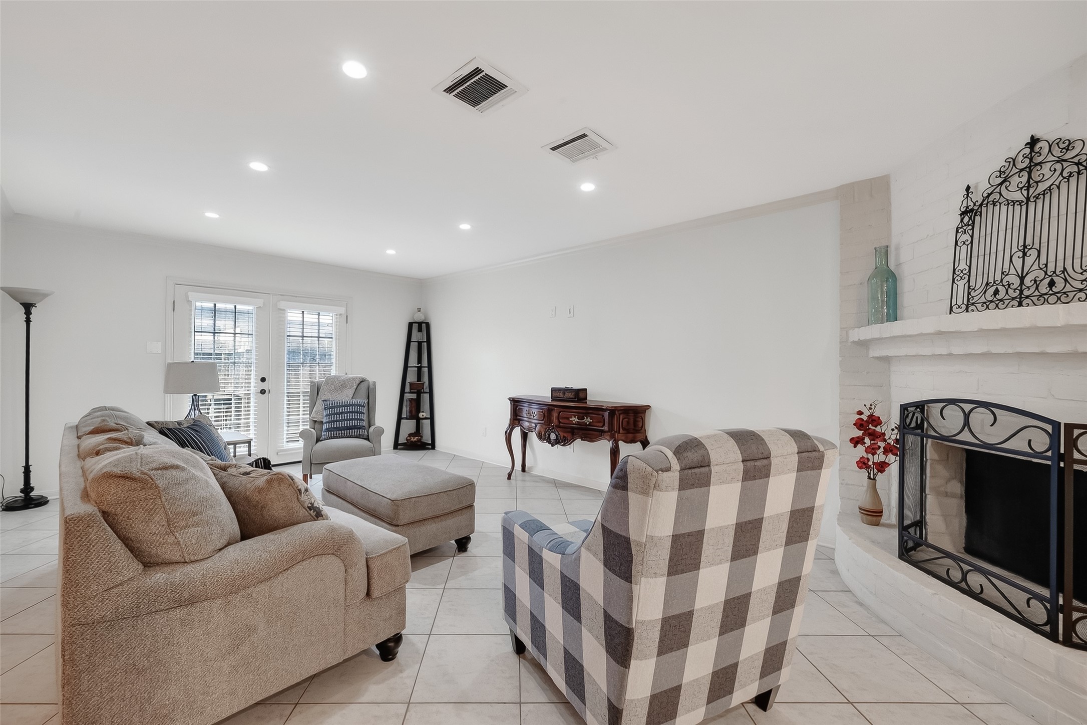 14690 Perthshire Road, Unit C Houston, TX 77079 - Photo 23 of 48 Dramatic floor-to-ceiling masonry defines the fireplace, while glass-paneled double doors connect the living area to the private rear patio.