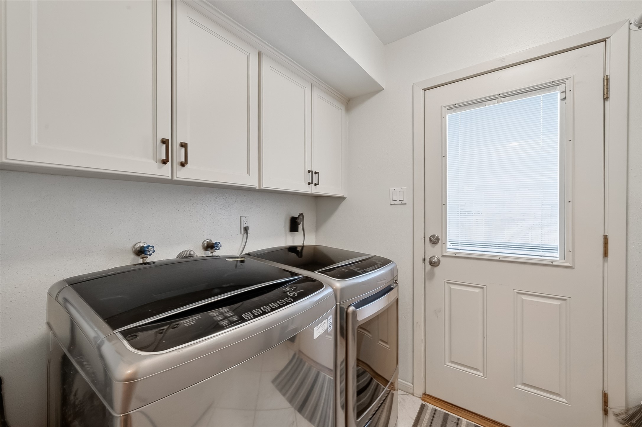 14690 Perthshire Road, Unit C Houston, TX 77079 - Photo 28 of 48 The laundry suite is a model of efficiency, offering crisp cabinetry and a glass-paned door that keeps the workspace energized with natural light.
