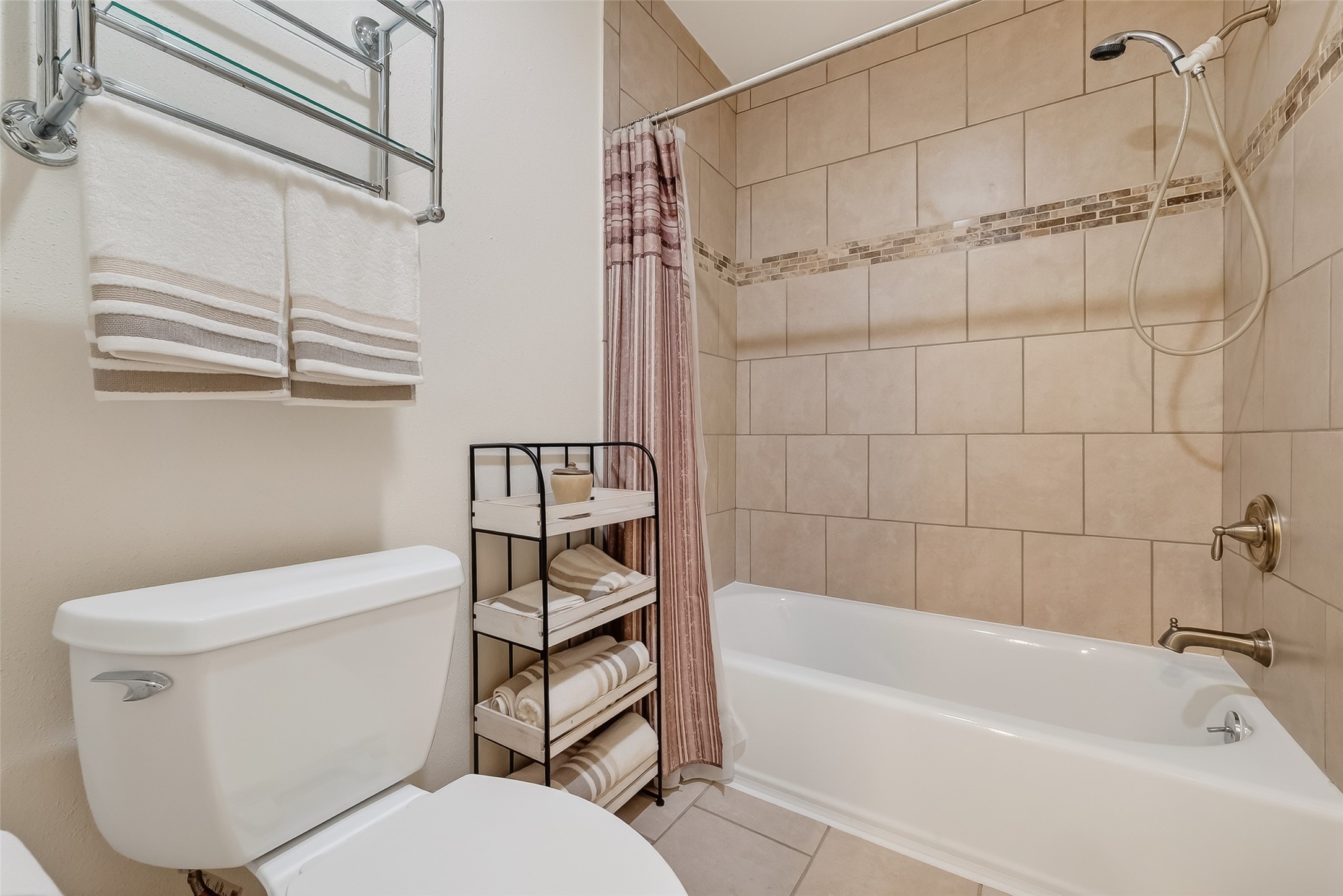 14690 Perthshire Road, Unit C Houston, TX 77079 - Photo 41 of 48 The private bath is anchored by a tub-and-shower combination in a nice tile surround, complemented by sleek fixtures.