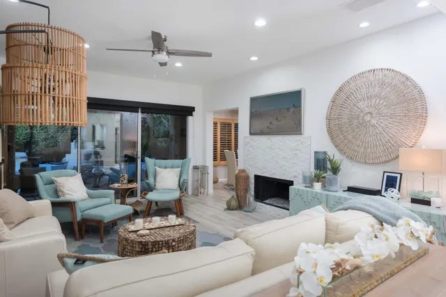 a living room with furniture a fireplace and a chandelier
