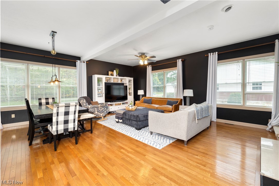 2097 Butler Road Wakeman, OH 44889 - Photo 5 of 34 Hardwood floored living room featuring ceiling fan with notable chandelier and beamed ceiling