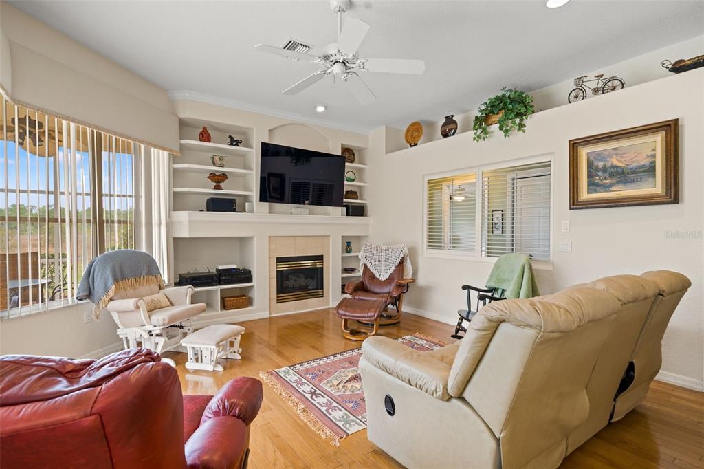 8405 Maybelle Drive Weeki Wachee, FL 34613 - Photo 14 of 61 a living room with furniture a fireplace and a flat screen tv