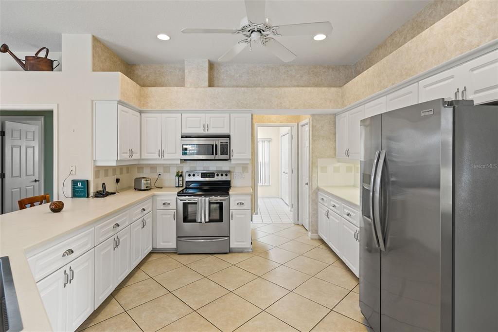 8405 Maybelle Drive Weeki Wachee, FL 34613 - Photo 10 of 61 a kitchen with stainless steel appliances a refrigerator sink and cabinets