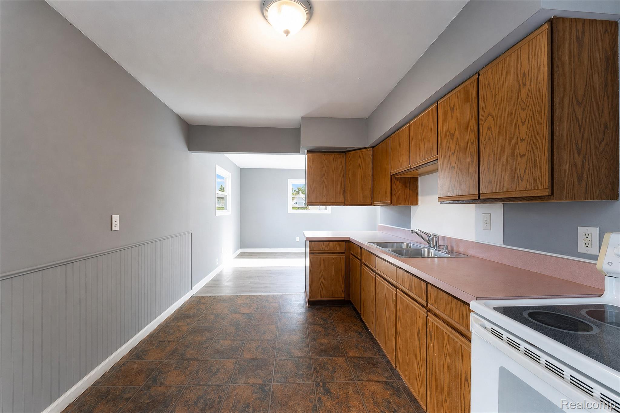 26137 Superior Road Taylor, MI 48180 - Photo 17 of 34 Galley kitchen featuring wood cabinetry, laminate countertops, and a white electric range