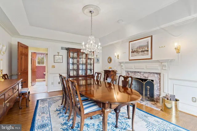 a dining room with furniture a chandelier and wooden floor