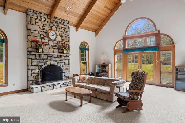 a living room with furniture a fireplace and a floor to ceiling window