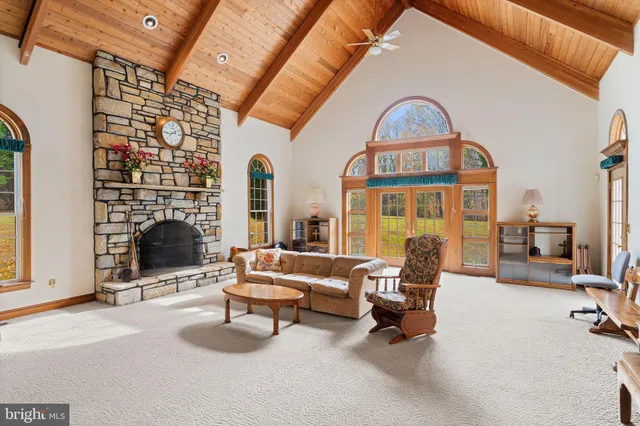 a living room with furniture a fireplace and a floor to ceiling window