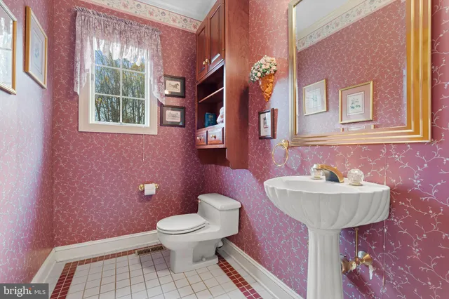 a bathroom with a sink toilet and a mirror