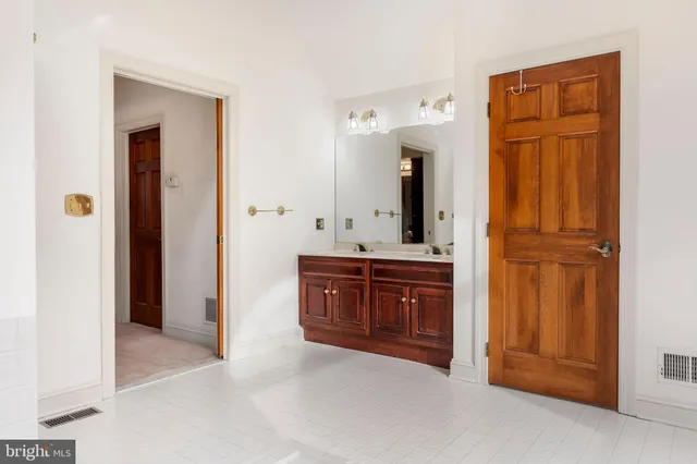 a spacious bathroom with a mirror and a sink