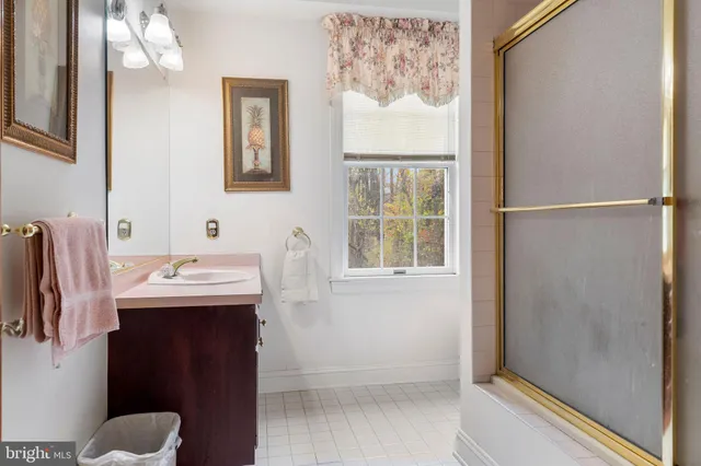 a bathroom with a sink and mirror with bathtub