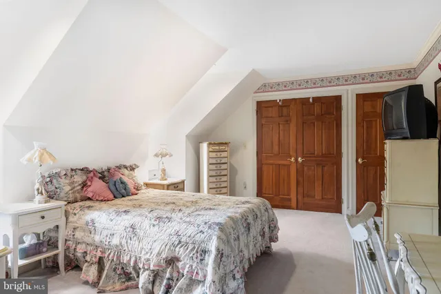 a bedroom with a large bed and a chandelier