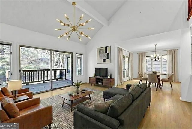 a dining room with furniture a chandelier and wooden floor
