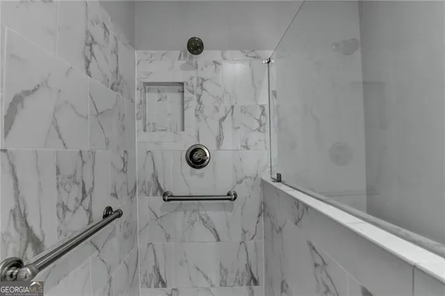 a bedroom with a bed a mirror and a large window