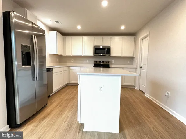 a kitchen with kitchen island a sink stainless steel appliances and cabinets