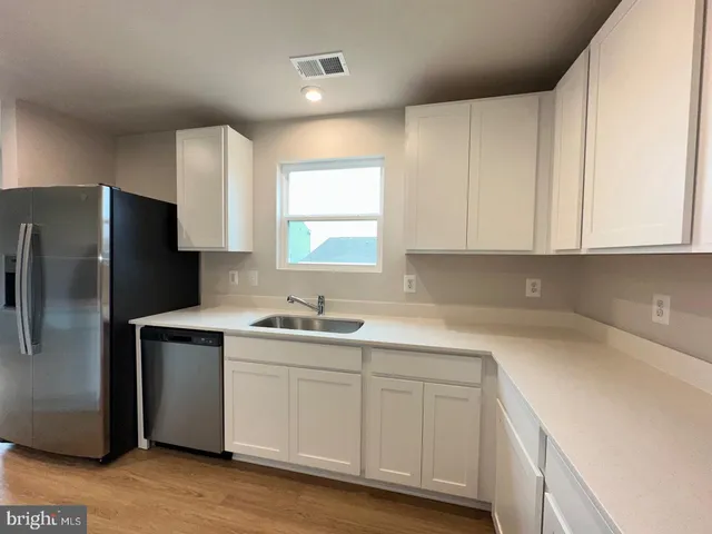 a kitchen with a sink cabinets and stainless steel appliances