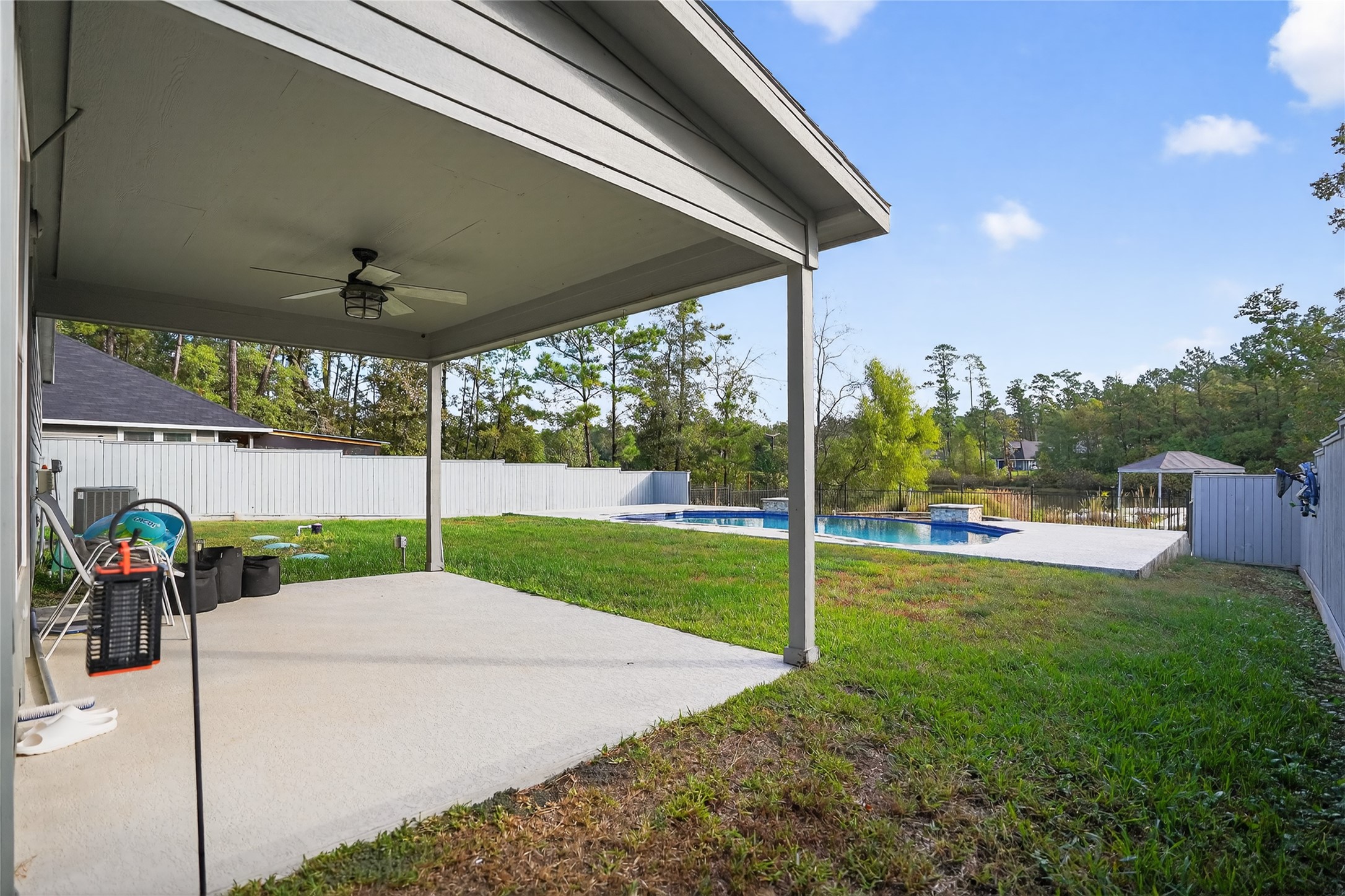 14986 Crockett Road Willis, TX 77378 - Photo 14 of 16 a view of a backyard with table and chairs under an umbrella