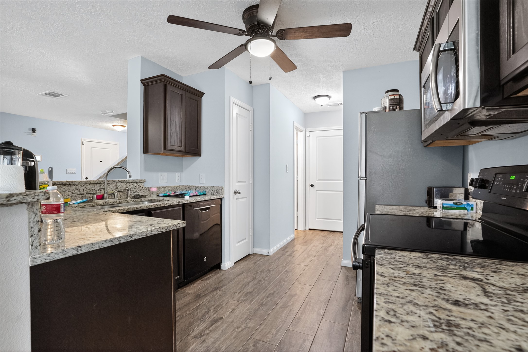 14986 Crockett Road Willis, TX 77378 - Photo 3 of 16 a kitchen with stainless steel appliances granite countertop a sink stove and refrigerator