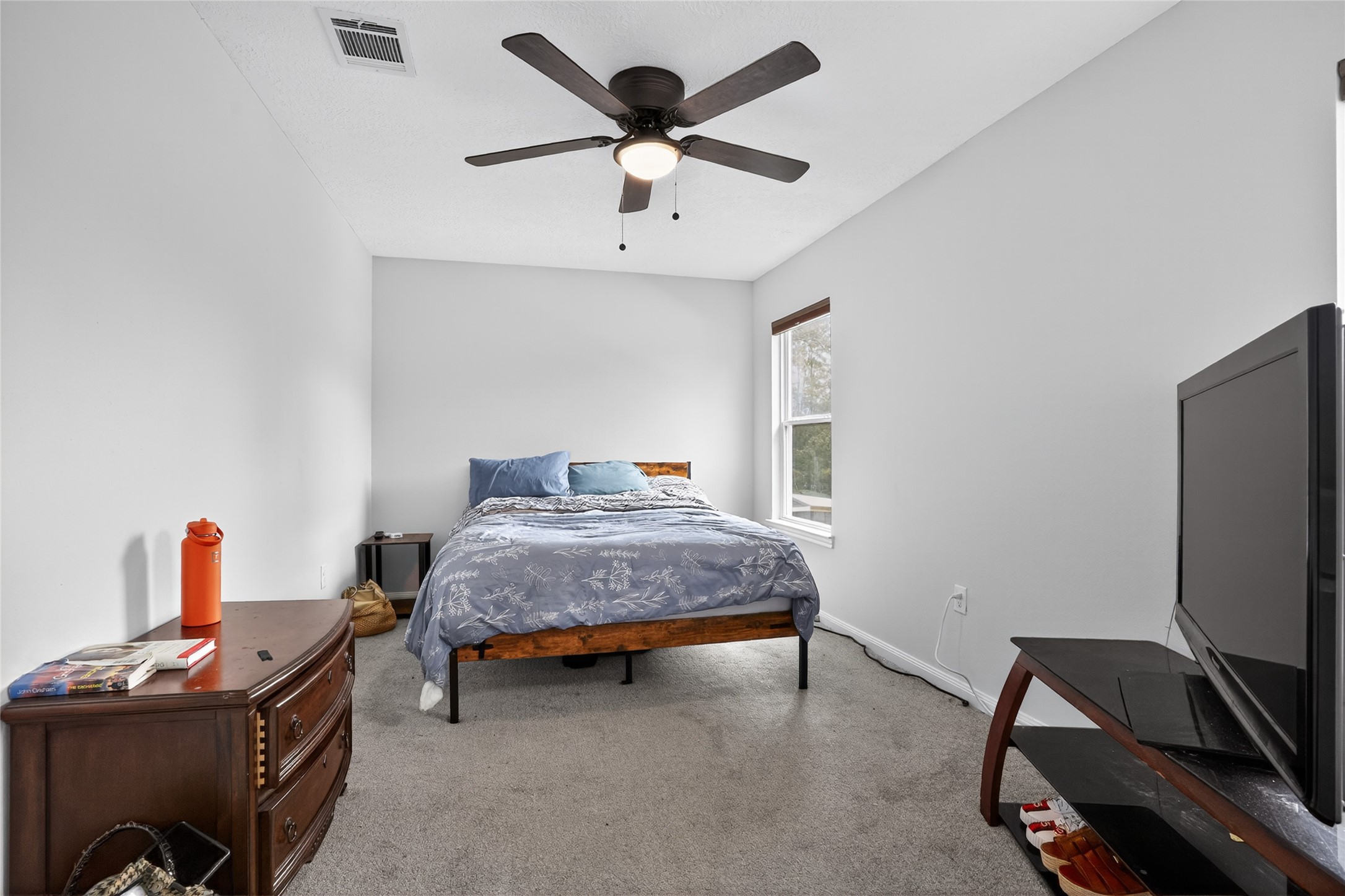 14986 Crockett Road Willis, TX 77378 - Photo 8 of 16 a bedroom with a bed and a flat screen tv