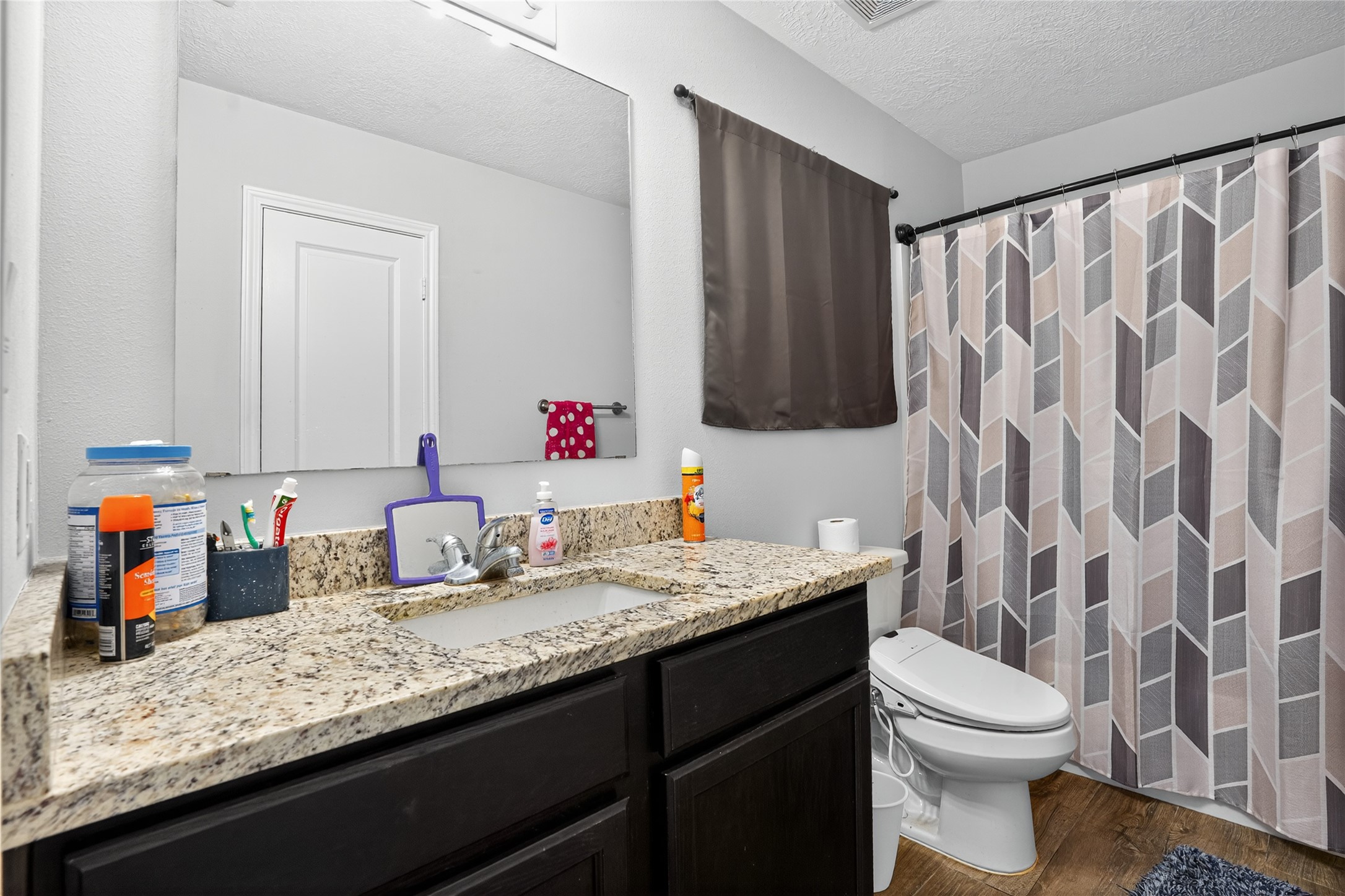 14986 Crockett Road Willis, TX 77378 - Photo 9 of 16 a bathroom with a granite countertop sink mirror vanity and toilet