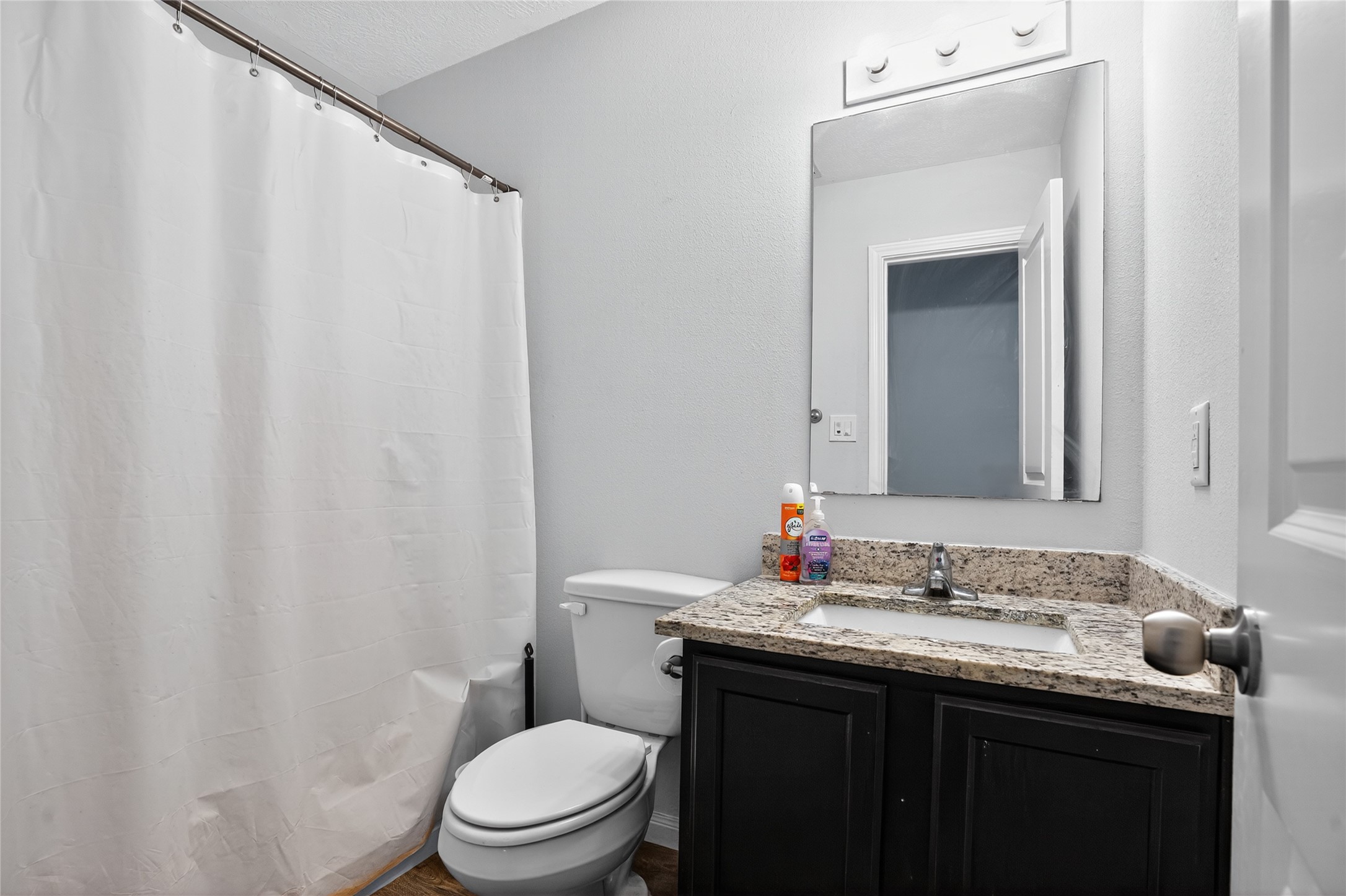14986 Crockett Road Willis, TX 77378 - Photo 10 of 16 a bathroom with a granite countertop sink vanity mirror and toilet