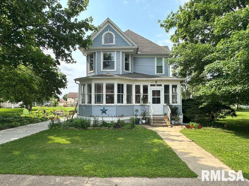 605 Fulton Street Grand Mound, IA 52751 - Photo 1 of 16 a front view of a house with a yard table and chairs