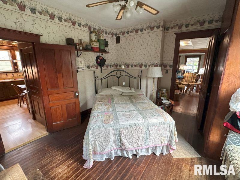 605 Fulton Street Grand Mound, IA 52751 - Photo 12 of 16 a bedroom with a bed and wooden floor