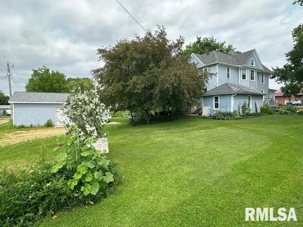 a view of a house with a big yard and large trees