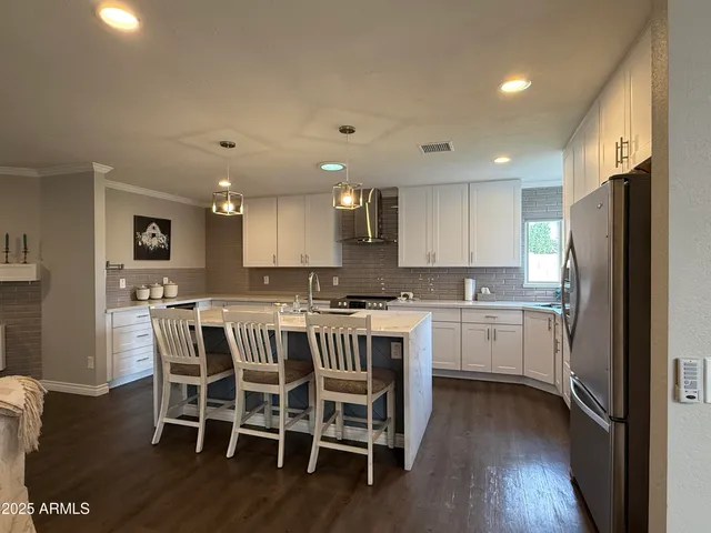 a kitchen with a table chairs refrigerator and microwave