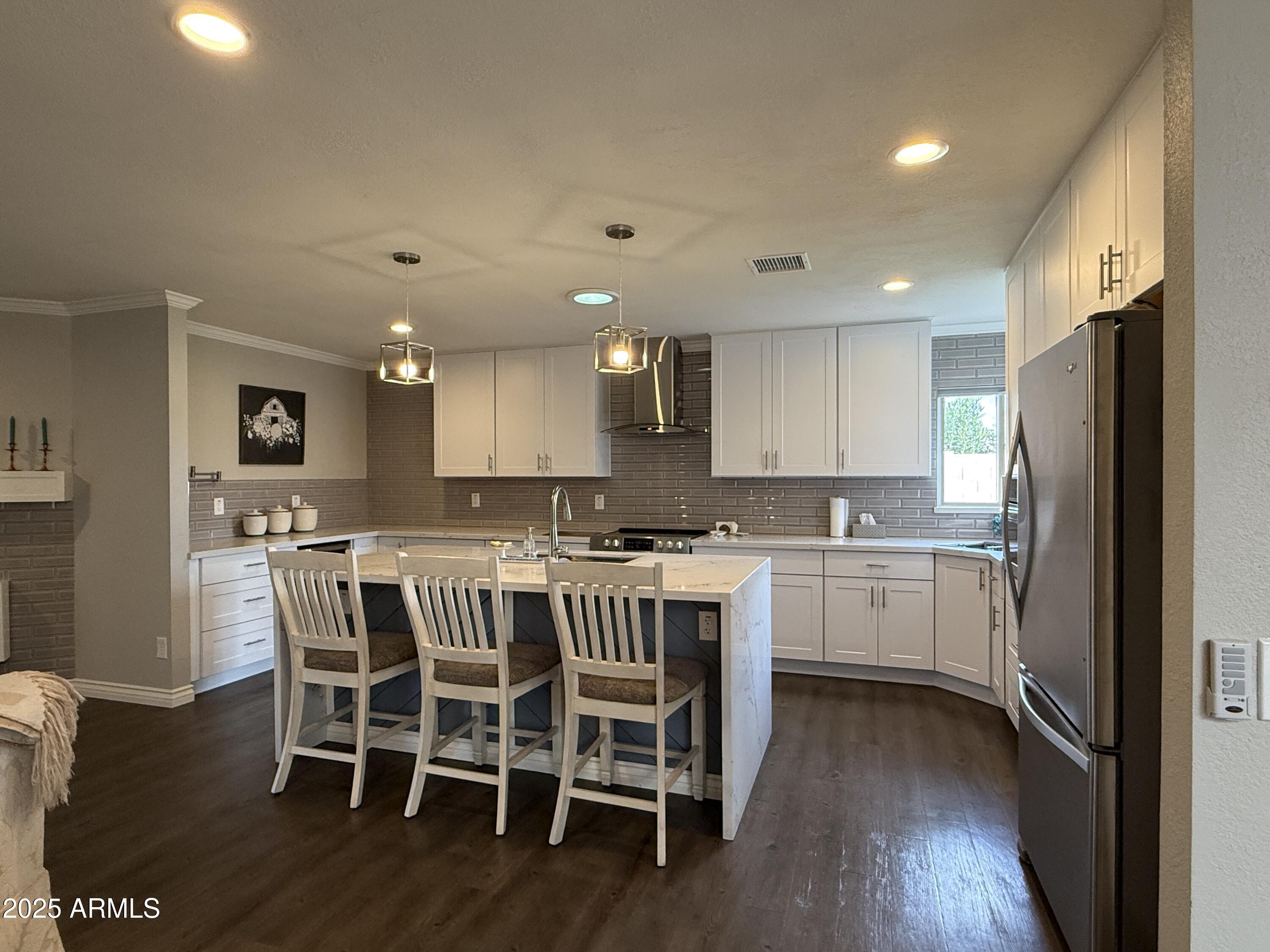 25208 South Angora Court Sun Lakes, AZ 85248 - Photo 5 of 22 a kitchen with a table chairs refrigerator and microwave