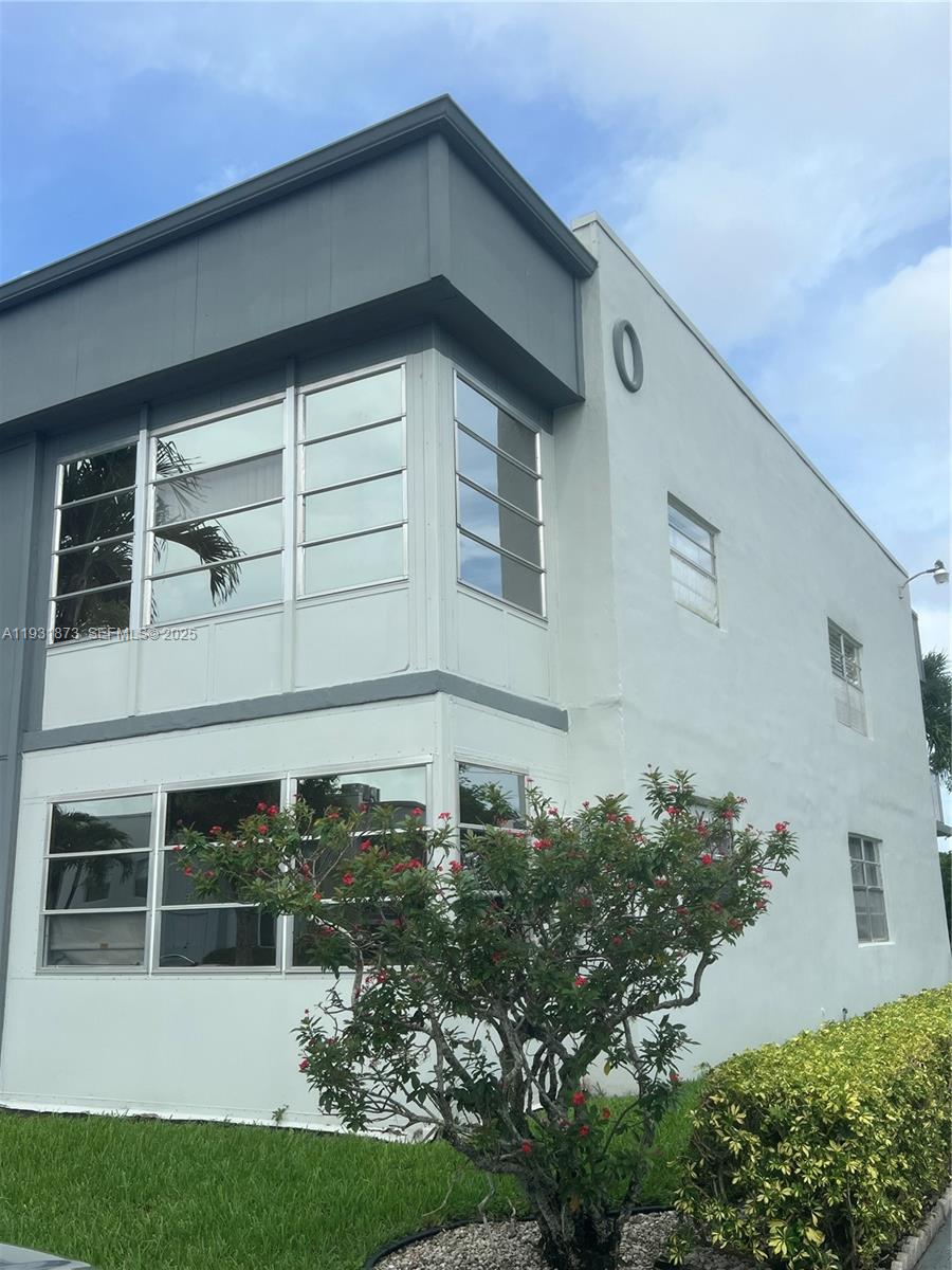 720 Burgundy L, Unit 720 Delray Beach, FL 33484 - Photo 2 of 17 a front view of a house with a garden