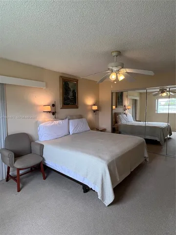 a spacious bedroom with a bed and a chair