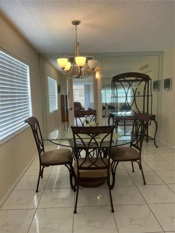 a view of a dining room with furniture and chandelier