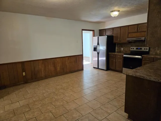 a kitchen with stainless steel appliances a refrigerator and a stove top oven