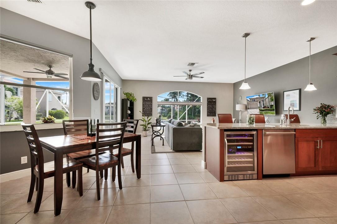 9685 Vineyard Court Boca Raton, FL 33428 - Photo 8 of 45 a kitchen with stainless steel appliances kitchen island granite countertop a table chairs and a wooden floor