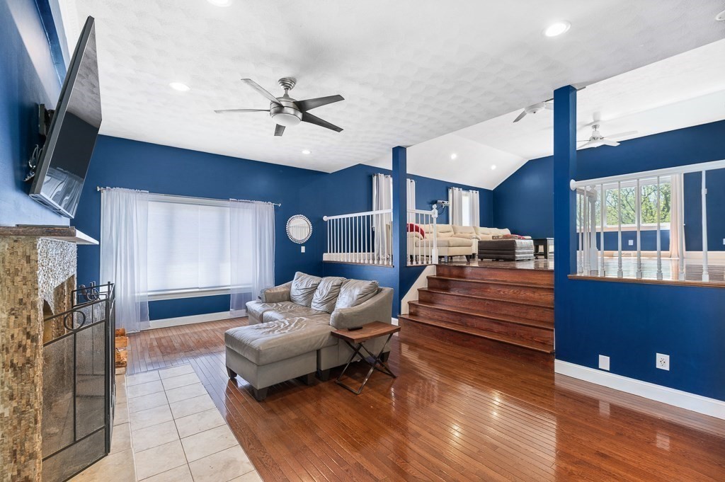 20 Landers Road Stoneham, MA 02180 - Photo 11 of 36 a living room with furniture a fireplace and a flat screen tv