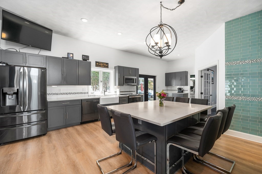 20 Landers Road Stoneham, MA 02180 - Photo 7 of 36 a kitchen with stainless steel appliances granite countertop a sink refrigerator dining table and chairs